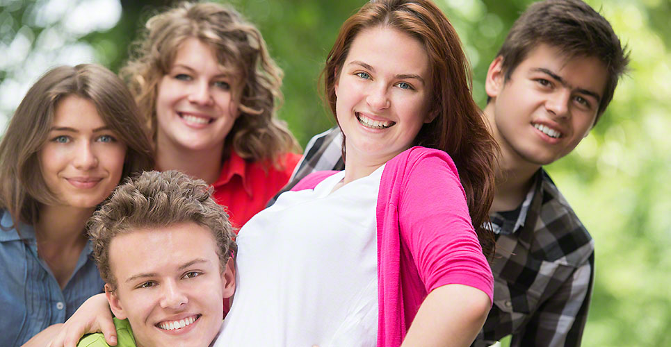 Five cheerful teenagers posing
